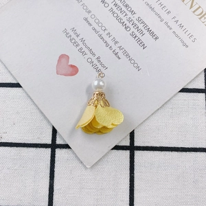 Detail of yellow fabric floral pendant with white pearl and gold metal ring for DIY jewelry