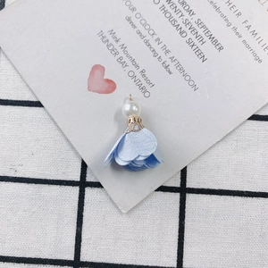 Detail of light blue fabric flower pendant with faux pearl and gold metal floral cap