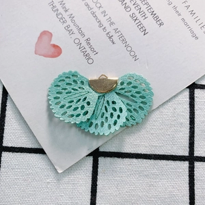 Close-up of mint green fan-shaped fabric pendant with gold clasp for DIY jewelry