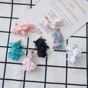 Gros plan de pendentifs pétales en mousseline colorée avec anneaux dorés pour boucles d'oreilles
