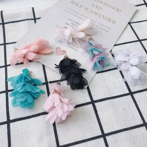 Gros plan de breloques fleurs en mousseline faites main avec anneaux dorés pour bijoux