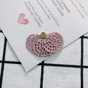 Detail of dusty pink lace flower accessory with intricate mesh texture and gold metal clasp