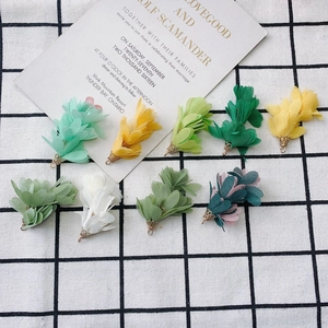Détail de breloques fleurs en mousseline avec coupelles dorées pour création de bijoux