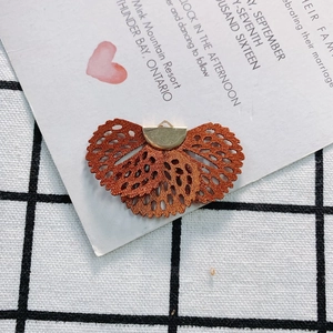 Macro view of vintage bronze fan-shaped fabric embroidery pendant for DIY jewelry making