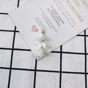 Vue détaillée de pendentifs fleurs à pompons blancs avec attaches dorées pour bijoux DIY