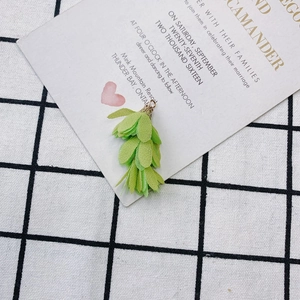 Vue détaillée du pompon en feuille de tissu vert clair avec capuchon doré pour bijoux DIY