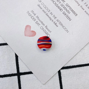 Détail d'une perle ronde en verre avec motifs de tourbillons colorés pour bijoux DIY