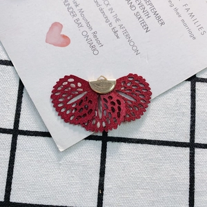 Close-up of wine red fan-shaped lace pendant charm with golden metal loop for DIY crafts