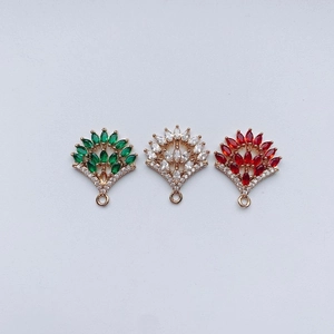Macro detail of fan-shaped alloy charms with emerald, ruby, and clear gems for DIY jewelry