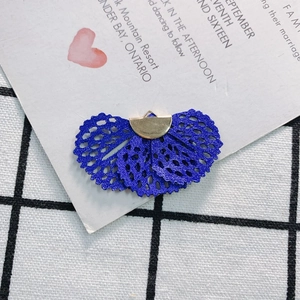 Close-up of a blue lace fan-shaped charm with a gold metal clasp for DIY jewelry