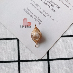 Detailed macro view of a 33x15mm pearl wrapped in gold wire pendant for DIY jewelry