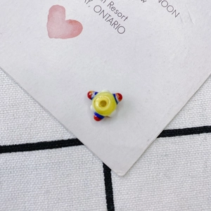 Primer plano de una cuenta de vidrio colorida con puntos arcoíris para joyas DIY