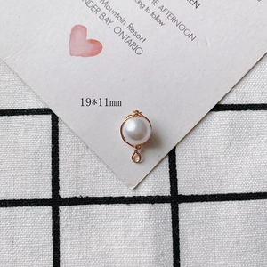 Close-up of 19x11mm pearl pendant with gold wire wrap on decorative background