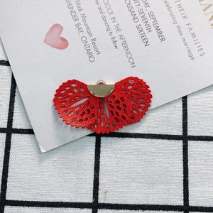 Detailed view of red fan-shaped lace pendant with golden metal loop for DIY jewelry