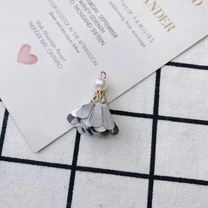 Macro detail of DIY flower earring pendant with pearl and grey fabric petals