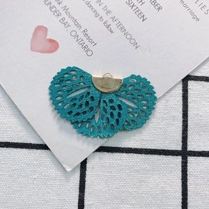 Detail of teal blue embroidered fan pendant with gold metal clasp for DIY jewelry