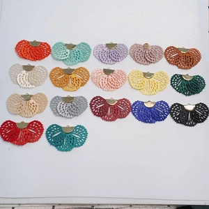 Flat lay of colorful lace fan charms with gold metal clips for DIY jewelry making