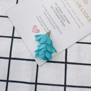 Détail d'un pendentif gland fleur en tissu bleu avec calotte dorée pour bijoux artisanaux