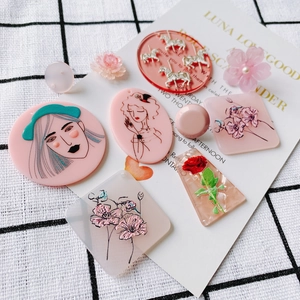 Close-up of pink acrylic relief pendants featuring vintage portrait and rose motifs
