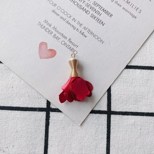 Detalle de colgante de rosa de tela roja con tapa dorada para crear bisutería