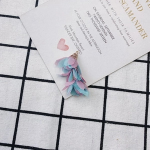 Gros plan d'un pendentif gland fleur rose et vert menthe avec capuchon en filigrane doré