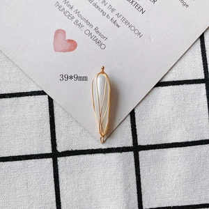 Detail shot of a 39x9mm pearl pendant wrapped in gold wire for DIY jewelry making