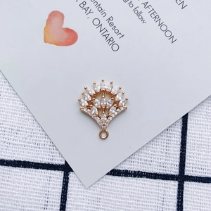 Macro detail of leaf-shaped gold alloy pendant with sparkling zircon for DIY jewelry