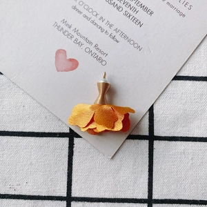 Detalle de colgante de rosa de seda amarilla con alambre dorado y perla blanca
