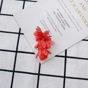 Détail de fleurs en tissu rouge pour bijoux DIY avec des pétales en mousseline douce