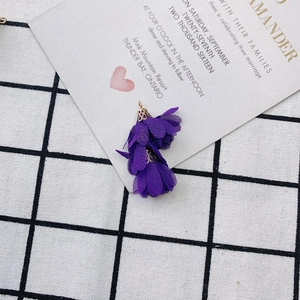 Gros plan sur le pendentif fleur en tissu violet avec capuchon doré pour bijoux DIY