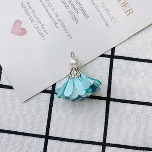 Detailed view of handmade light blue and white fabric flower pendant with a pearl