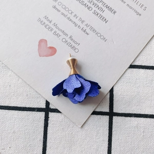 Detalle de colgante de rosa de tela azul real con alambre dorado y cuenta blanca fina