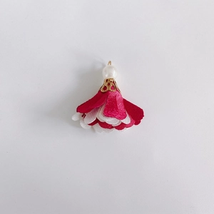 Detail of multi-layer fabric flower charm with white pearl and gold metal petal cap