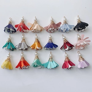 Flat lay of 18 colorful fabric flower tassels with pearls for DIY jewelry making