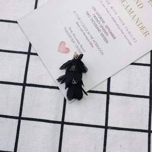 Détail d'un pendentif fleur DIY avec couches de mousseline noire et calotte dorée