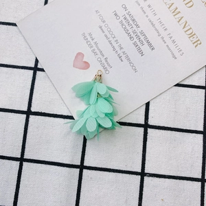 Gros plan du pendentif fleur en mousseline vert menthe avec capuchon doré pour bijoux DIY