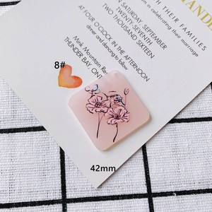 Detail view of 42mm pink acrylic floral pendant with black line art on wedding card