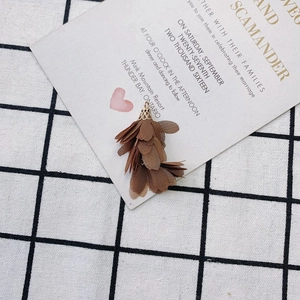 Détail d'un pendentif gland fleur en mousseline marron avec capuchon doré ciselé