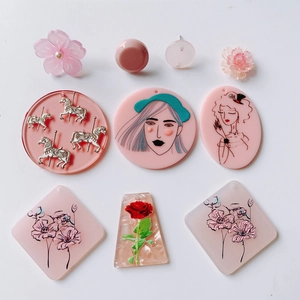 Flat lay of pink relief acrylic pendants with vintage girl portraits and floral designs
