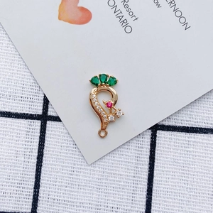 Macro shot of gold alloy earring pendant with emerald green and red zircon stones