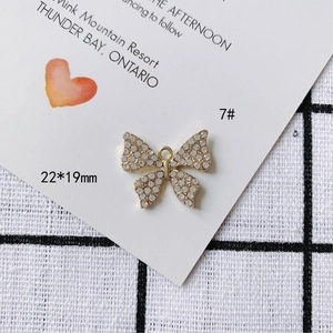 Vue macro du pendentif nœud en alliage doré 22x19mm avec perles et strass pour bijoux DIY