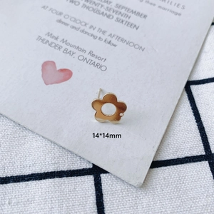 Close-up of 14x14mm gold geometric flower stud earrings with a hollow five-petal design