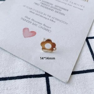 Macro shot of 14x14mm matte gold hollow flower charm with side loop connector
