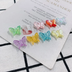 Macro shot of colorful translucent resin butterfly charms with detailed relief patterns