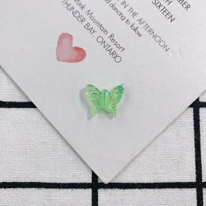 Detail of translucent green butterfly resin charm with fine textured wings for DIY jewelry