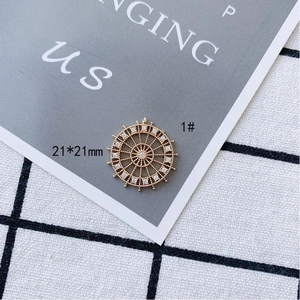 Detail of 21x21mm gold-plated ship wheel pendant with white zircon inlays on display