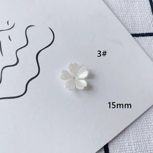 Macro shot of 15mm white acrylic flower charm with pearl finish for DIY jewelry making
