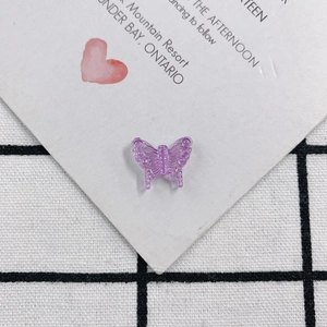 Macro detail of a purple translucent acrylic butterfly charm for DIY jewelry and crafts