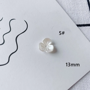 Macro view of 13mm white acrylic flower beads with central hole for DIY jewelry making