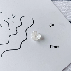 Macro shot of 11mm white acrylic flower DIY jewelry component on a minimalist card